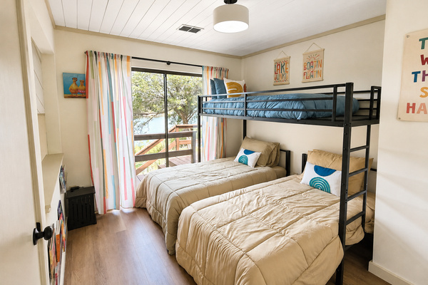Third bedroom with a twin bunk over two twin beds, comfortably sleeping 3 guests with direct deck access and lake views.