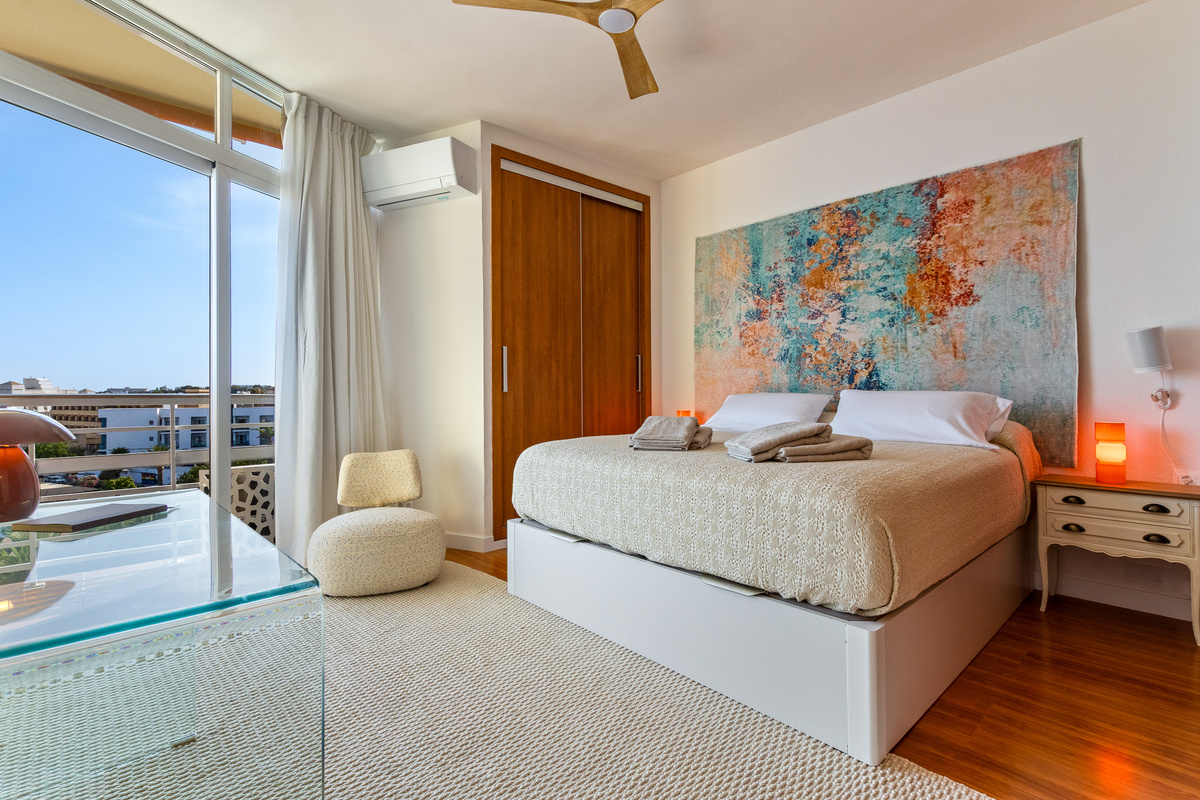 Sea-view bedroom with balcony access, wardrobe and calming design details.