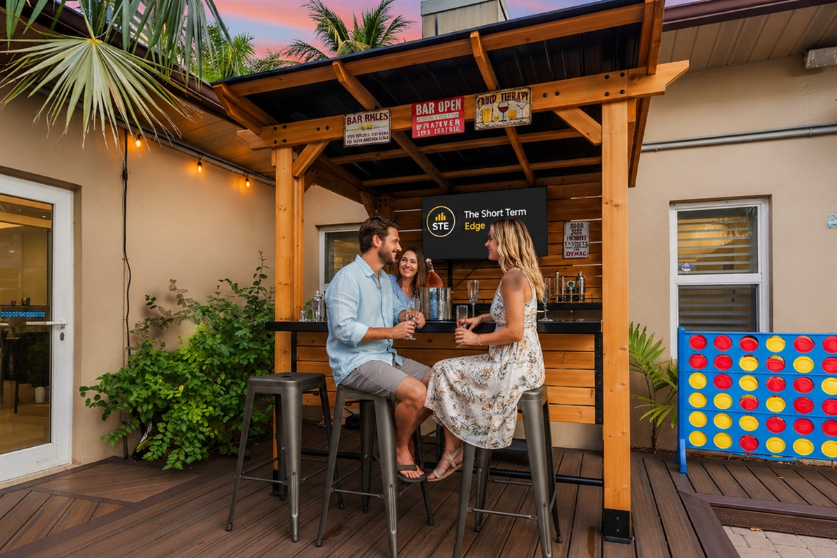Step into your private entertainment oasis 🍹 — an inviting outdoor bar with a 50” TV, warm lighting, and fun games that set the scene for relaxing and connecting.