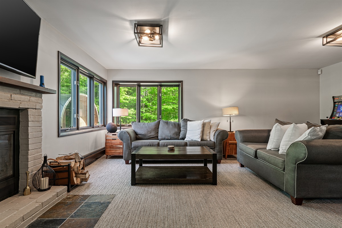 Unwind in the lower-level living room, equipped with a TV and cozy seating for movie nights or game days.
