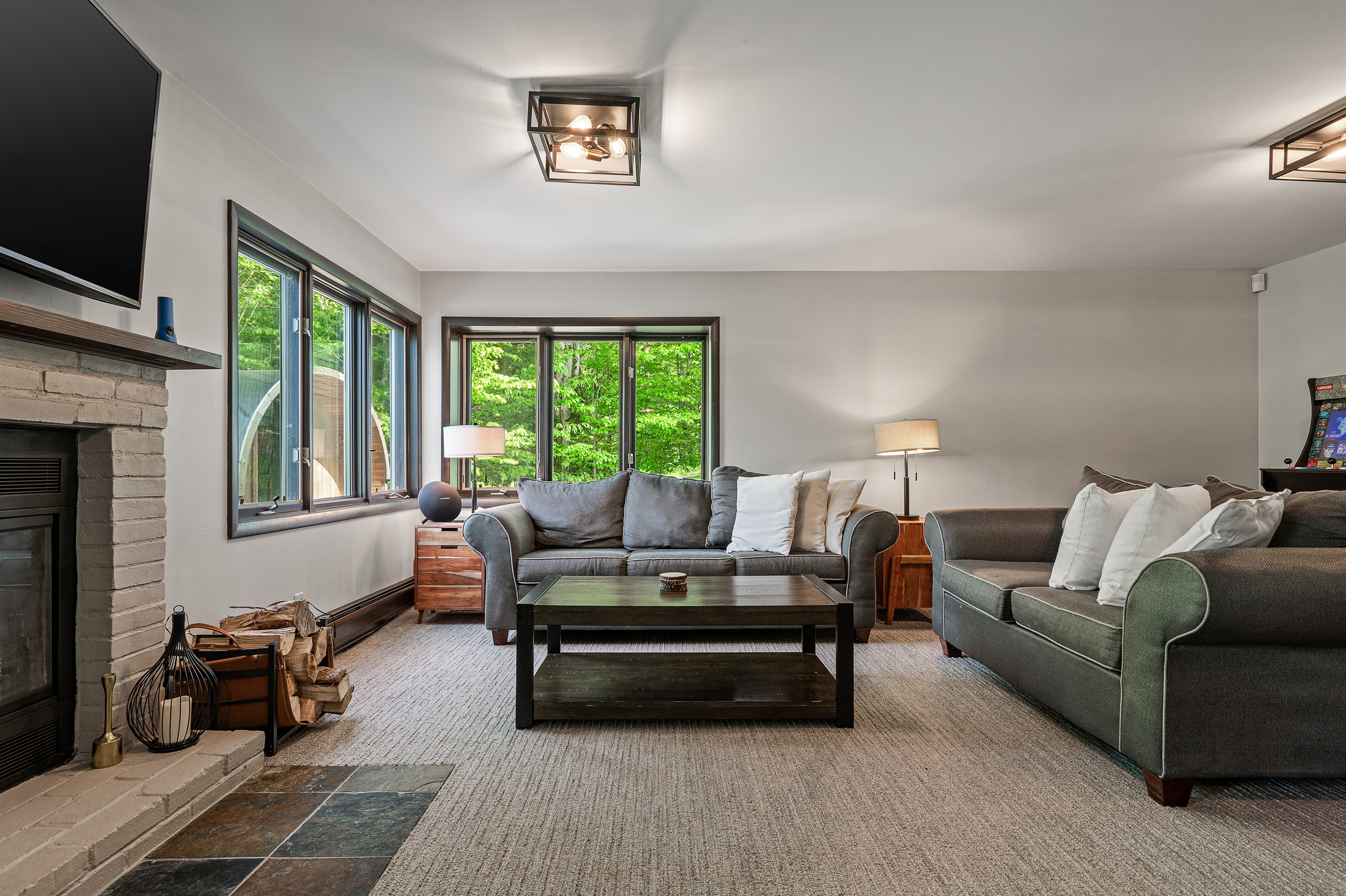 Unwind in the lower-level living room, equipped with a TV and cozy seating for movie nights or game days.