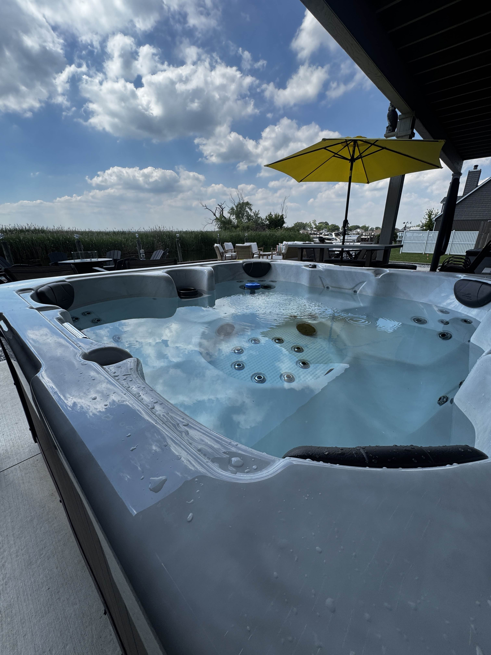Unwind in this private outdoor hot tub set on a beautiful waterfront patio. Enjoy warm, bubbling water while taking in open sky views, fresh air, and peaceful canal-side surroundings—perfect for relaxing evenings after a day of exploring.