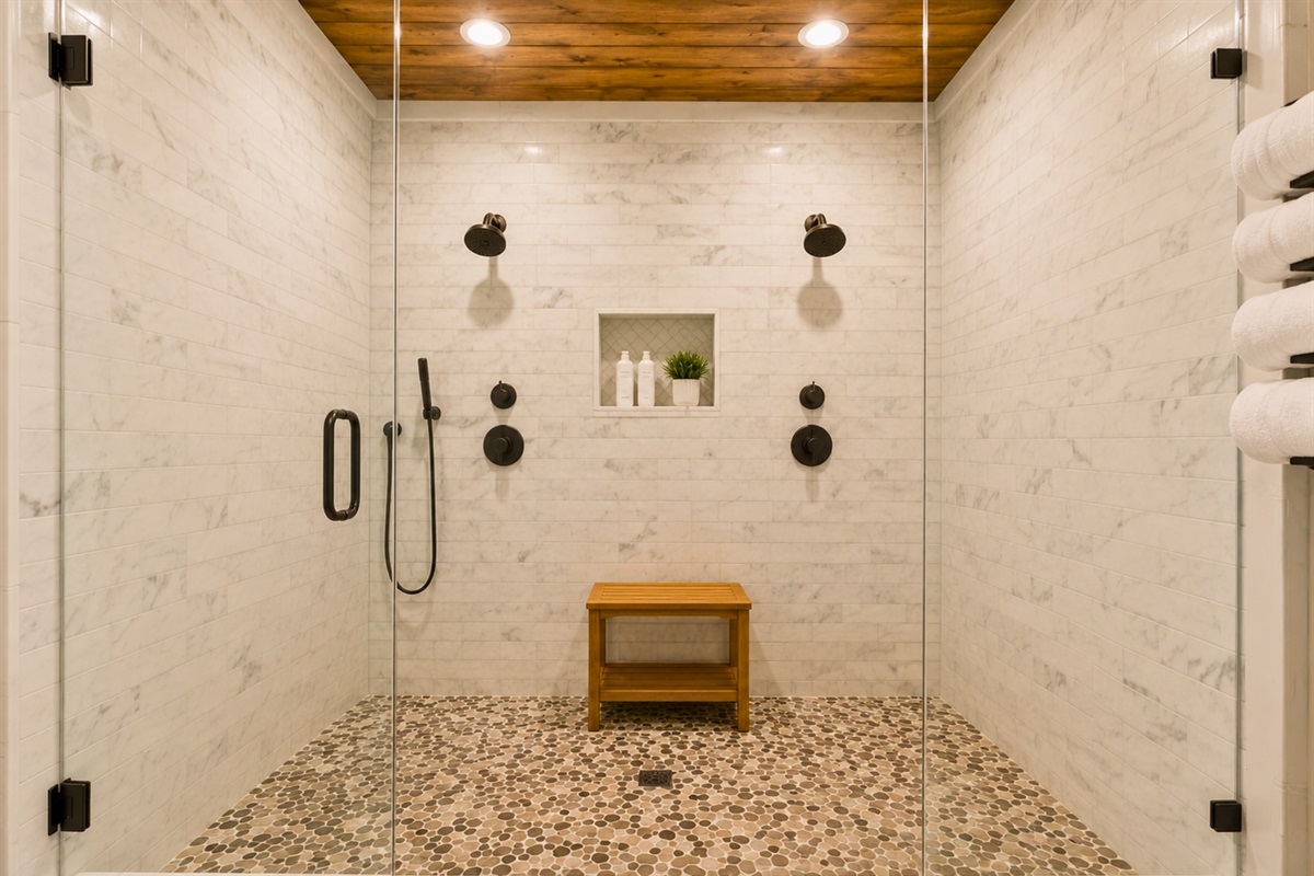 The oversized walk-in shower offers a luxurious spa-like experience with beautiful tilework and thoughtful design details throughout.
