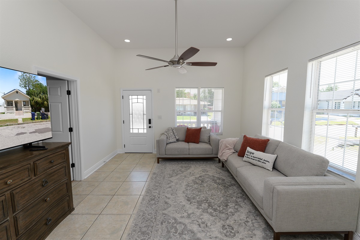 Soaked in natural sunlight, this welcoming living space features plush modern sofas and a smart TV for endless entertainment.