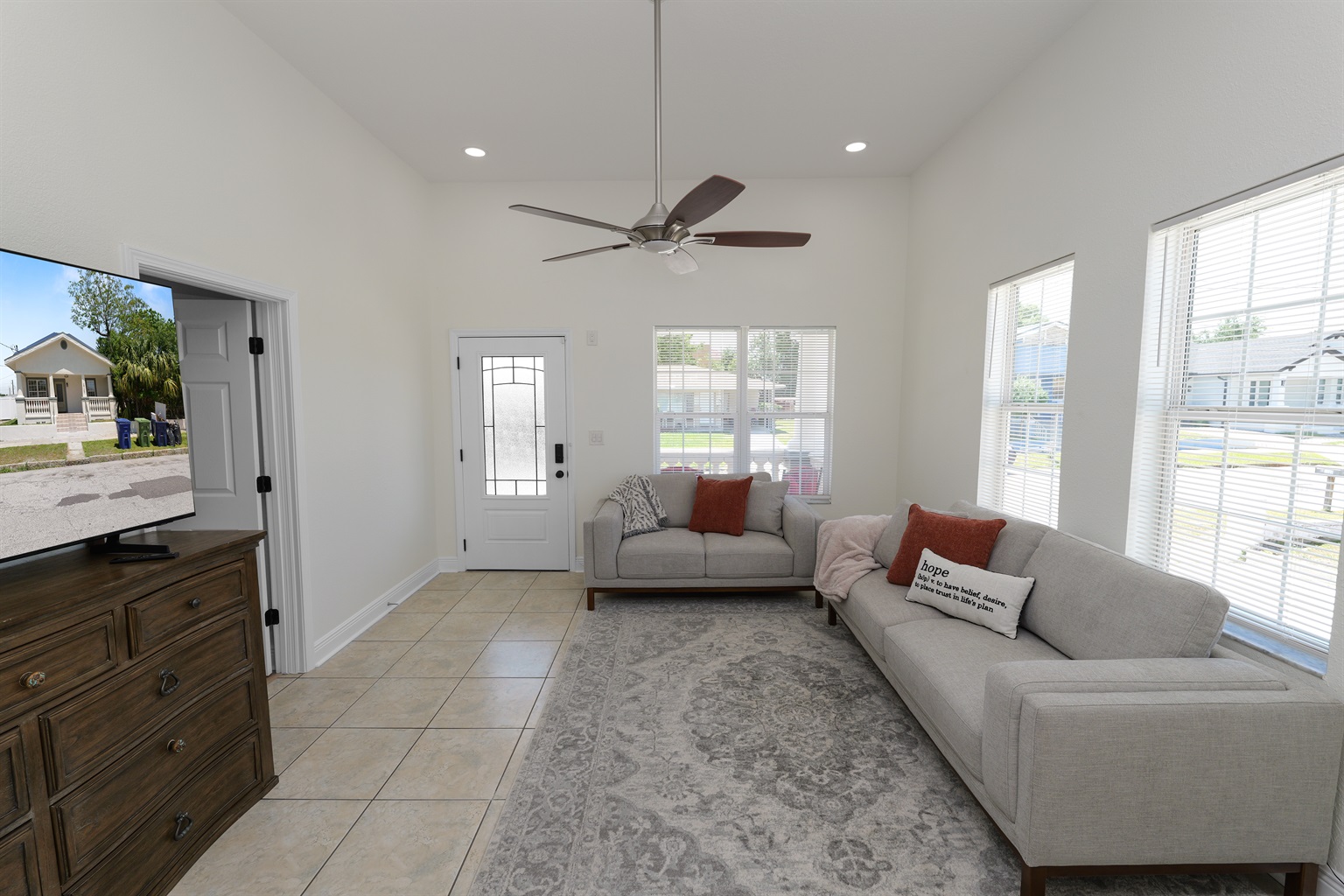 Soaked in natural sunlight, this welcoming living space features plush modern sofas and a smart TV for endless entertainment.