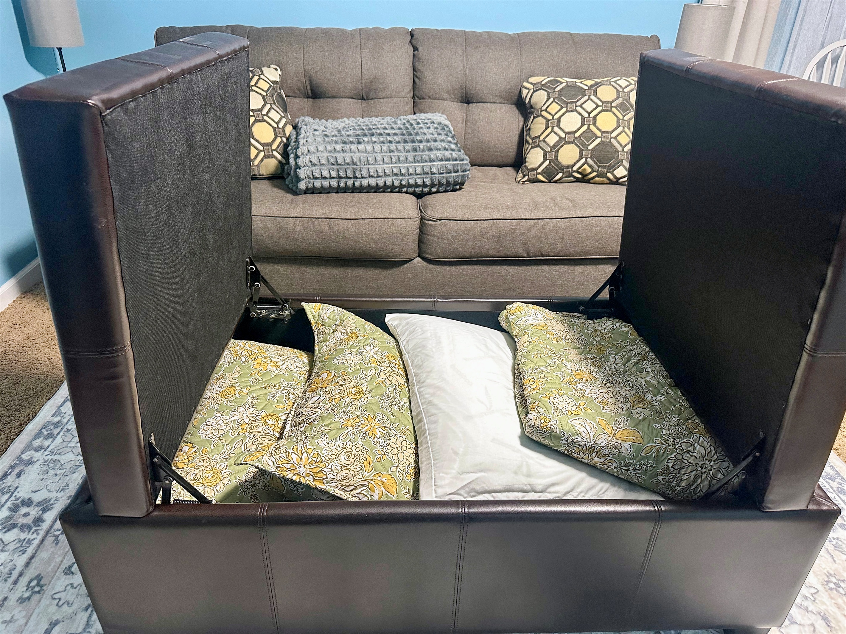 Storage ottoman in the lower-level suite containing bedding for the sleeper sofa, including linens and pillows so the space can easily convert into an additional sleeping area.