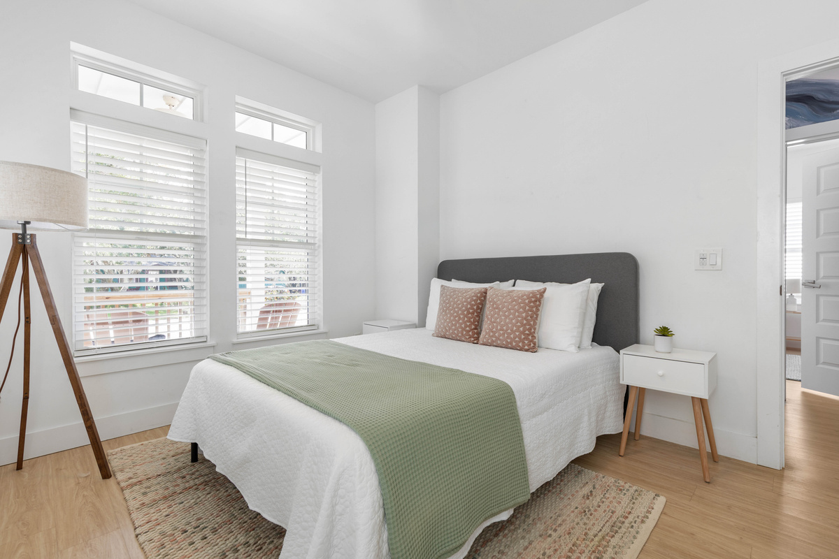 An upholstered headboard, a reading lamp within arm's reach, and a rug soft underfoot on the way to the door. Far enough back in the house that the noise from the pool never quite reaches the pillow at night.