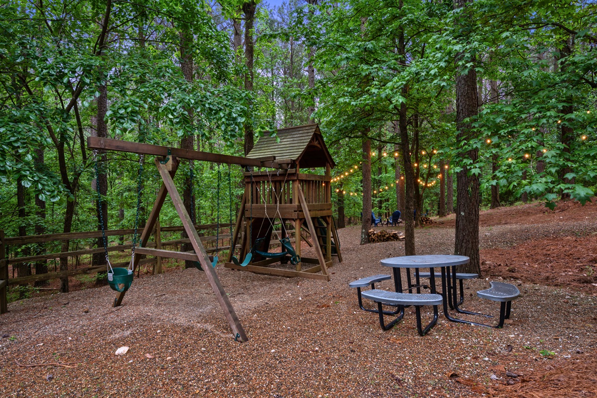 The backyard opens up to a fun and laid-back space with a playset and picnic table, making it easy for everyone to spend time outside together.