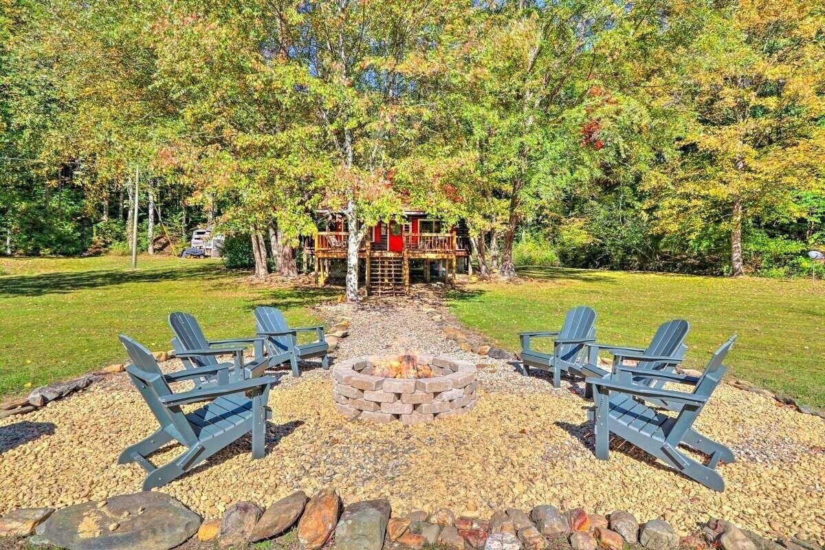 Outdoor firepit by the pond with Adirondack chairs for relaxing.