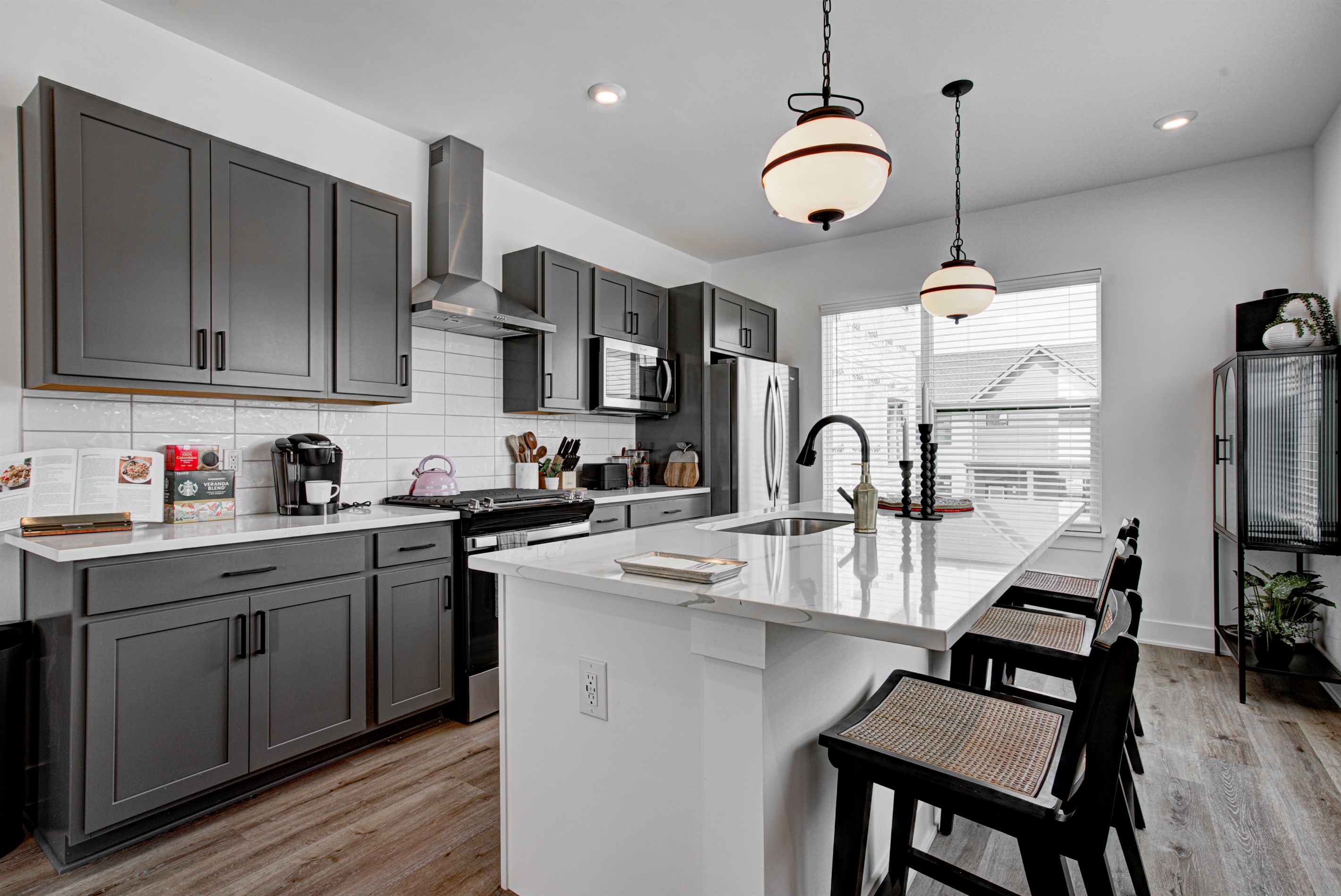 Enjoy a designed open-concept space with a modern kitchen equipped with quartz countertops, stainless steel appliances, and all essentials for home cooking. 