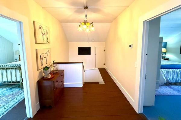At the top of the stairs, two bedrooms share a full bath and spacious landing, creating a comfortable retreat for family or friends. Vintage and custom lighting add character, while a separate thermostat keeps the whole floor just right.
 