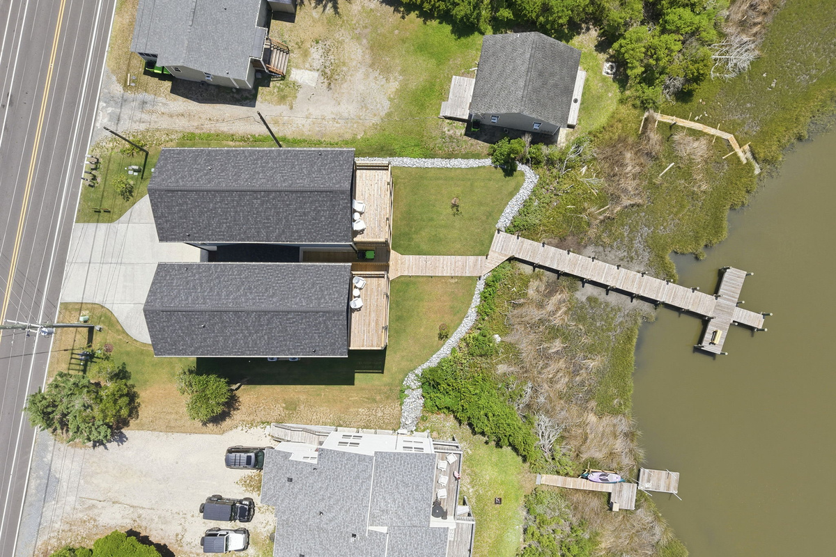 A straight-down aerial view captures the entire property layout, featuring the expansive backyard, private boardwalk, and dock extending into the marsh