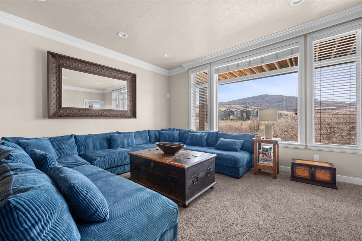 Comfortable living space with large windows showcasing beautiful mountainous scenery.