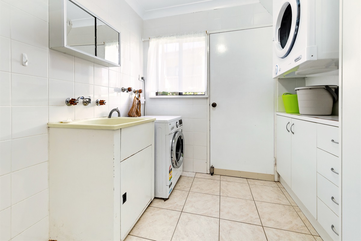The downstairs laundry gives Bertie’s 3 Beaches a dedicated utility space on the lower level, separate from the upstairs kitchen and living areas.