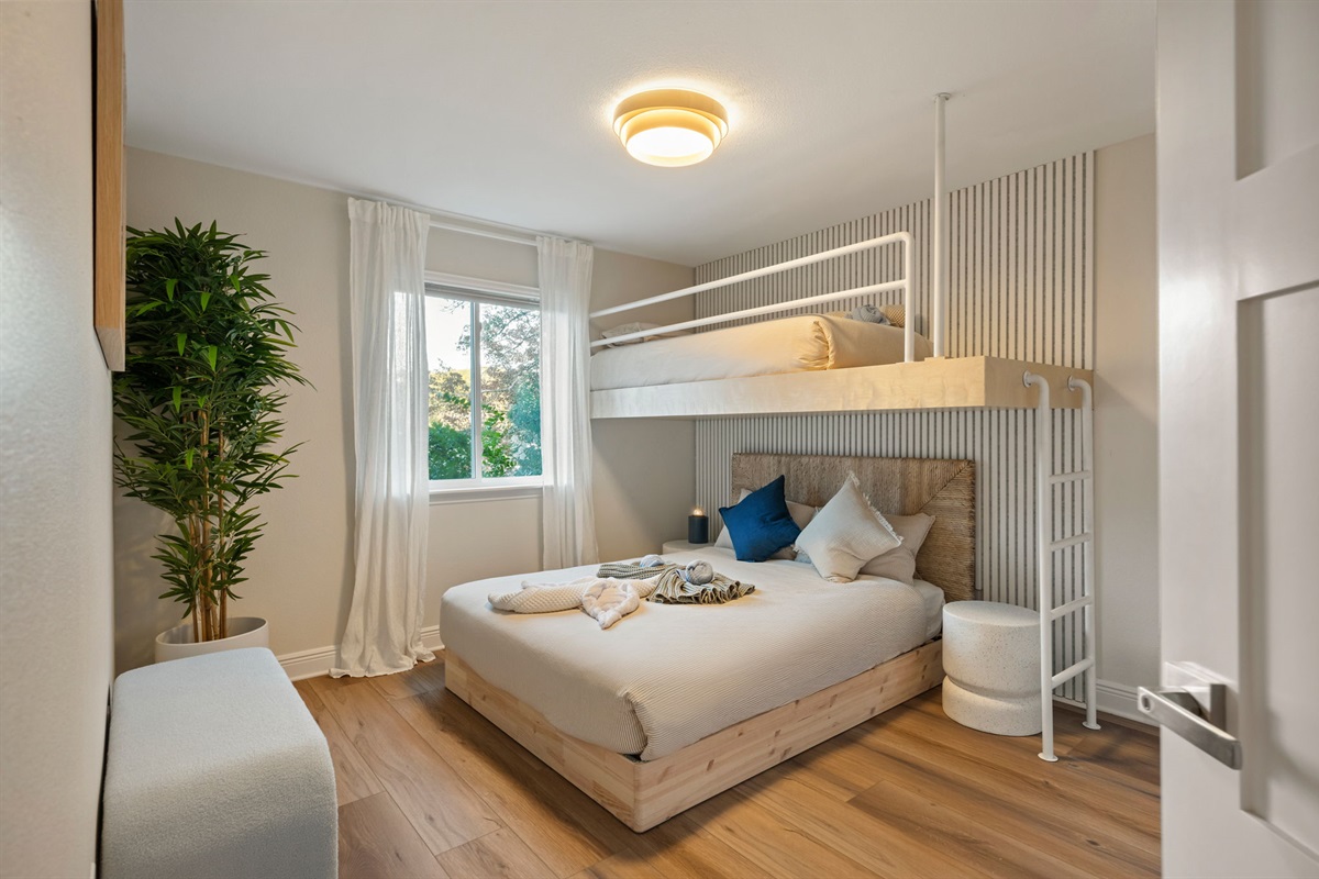 Fun bunk room perfect for kids or groups, featuring a queen bed and twin bunks.