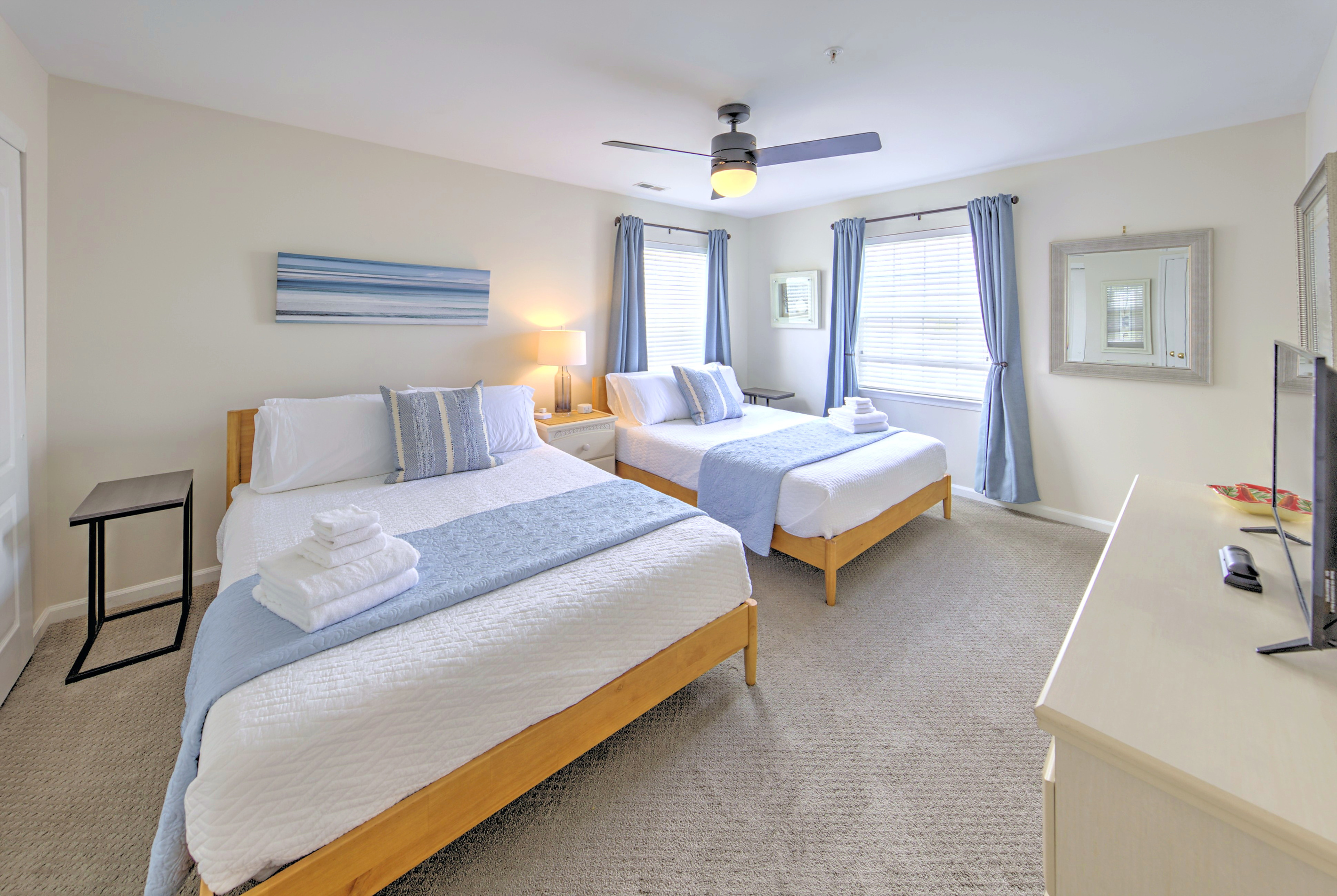 Fresh linens provided and beds professionally made before arrival—no linen rentals required.

Bedroom 2: Bright and airy retreat with two queen beds and serene coastal decor!