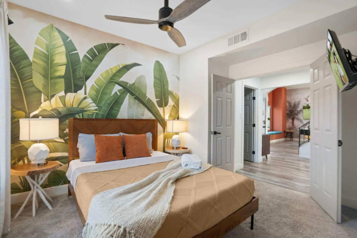 Serene bedroom with oversized tropical mural and easy access to other rooms.
