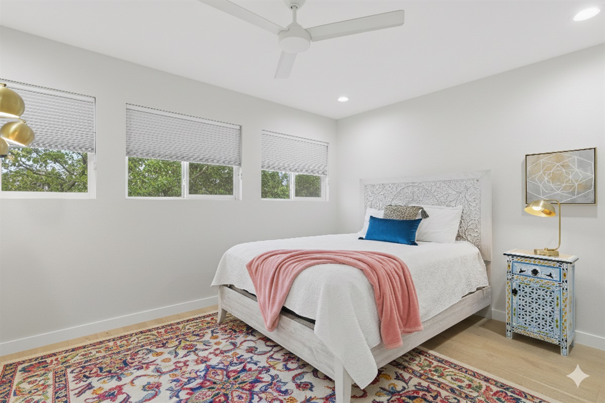 bedroom 1 with ensuite bathroom and queen bed, dresser, black out curtain