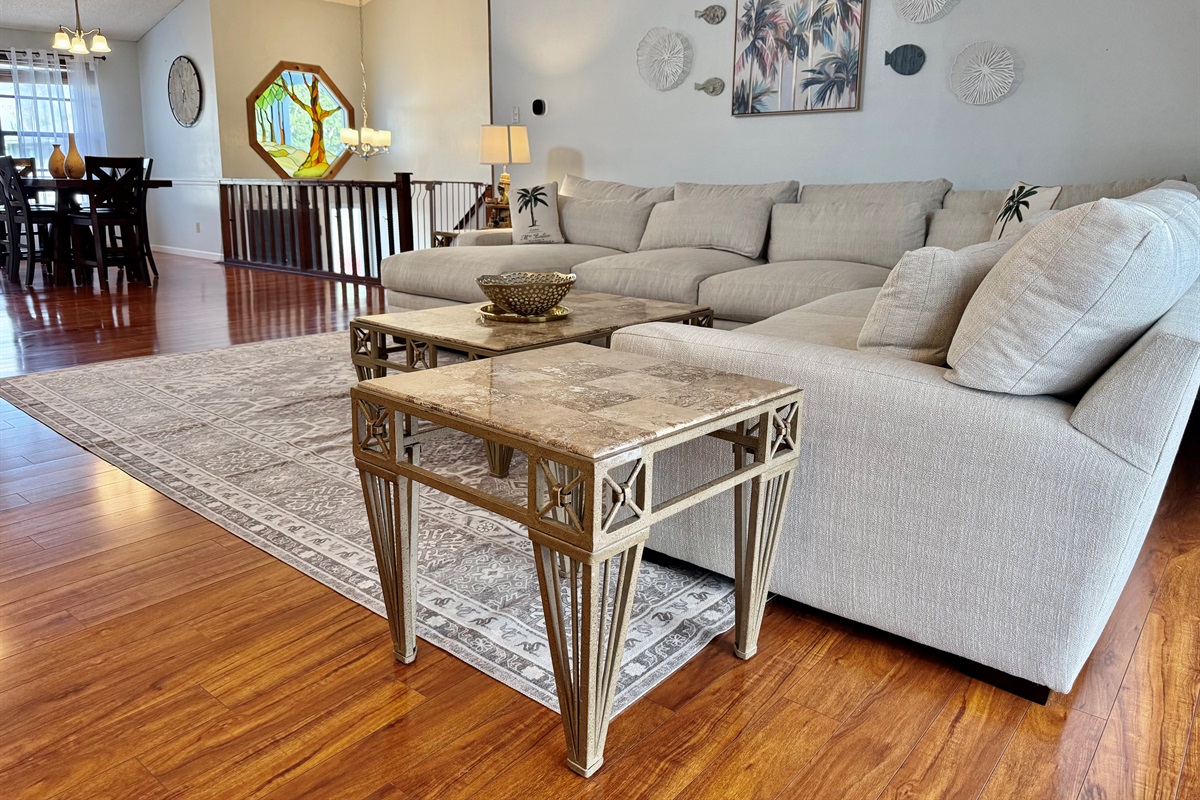 With rich hardwood floors, soaring ceilings, and a large, plush sectional, this is the kind of space that invites guests to kick off their shoes, sink in, and stay a while.