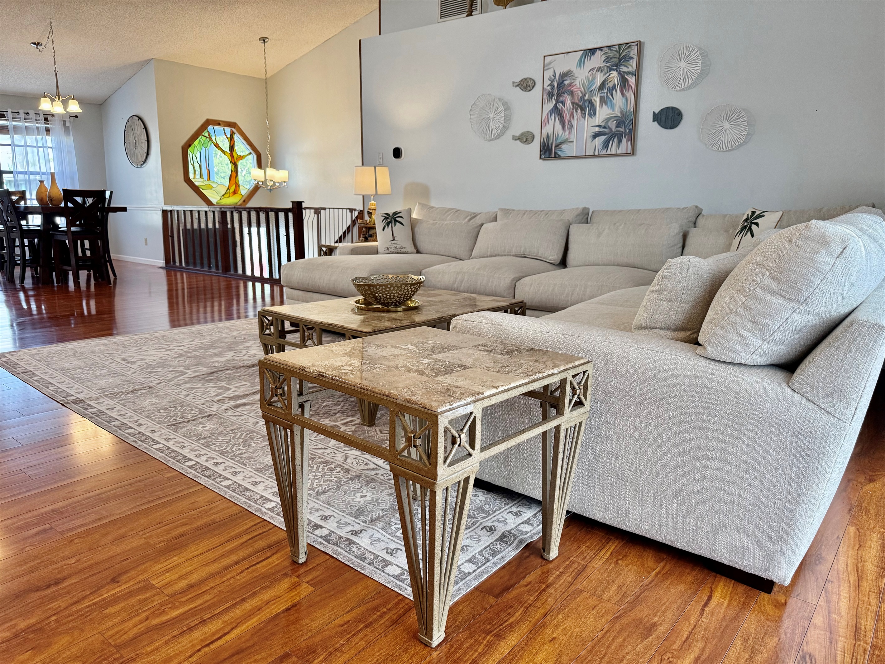 With rich hardwood floors, soaring ceilings, and a large, plush sectional, this is the kind of space that invites guests to kick off their shoes, sink in, and stay a while.