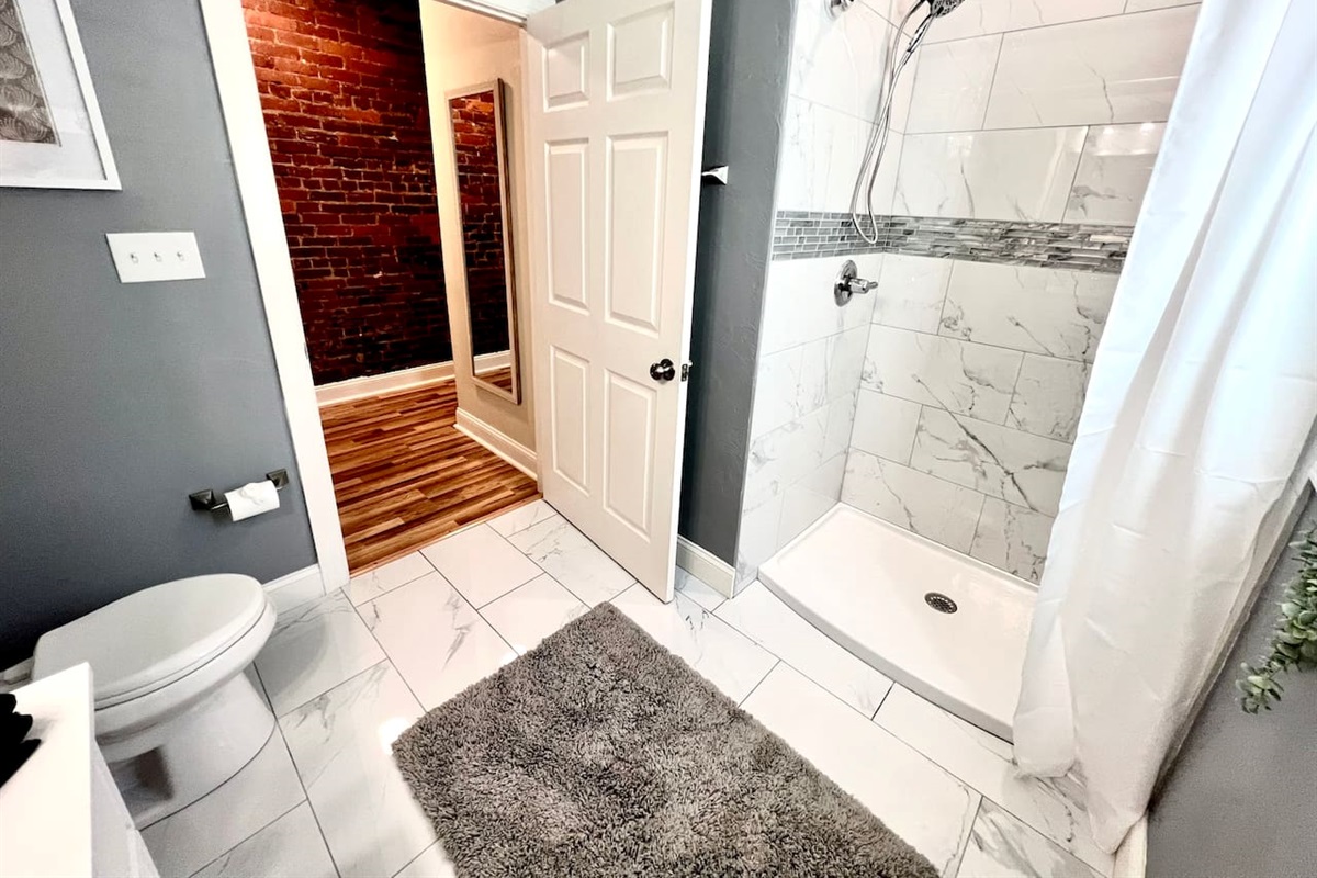 Bathroom featuring a toilet and shower, designed for your comfort and convenience.