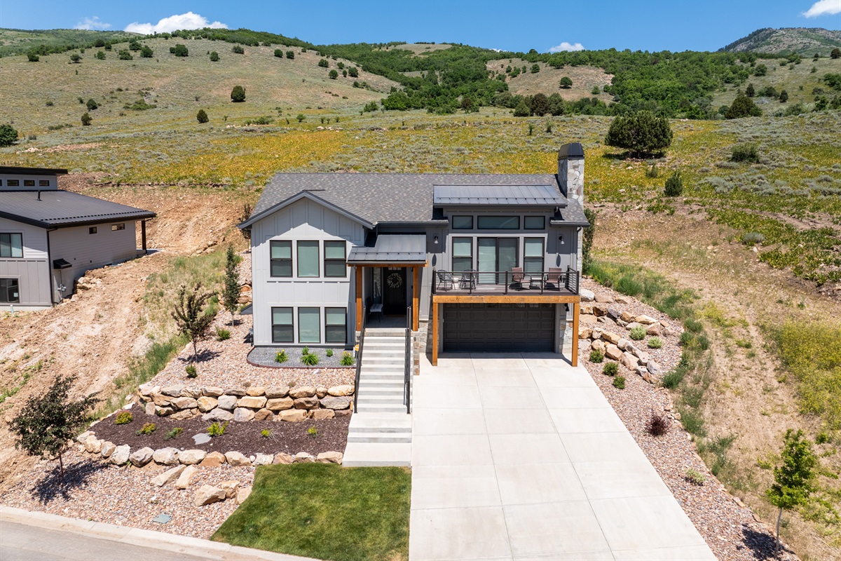 Front exterior view of the home with clean modern lines and mountain backdrop