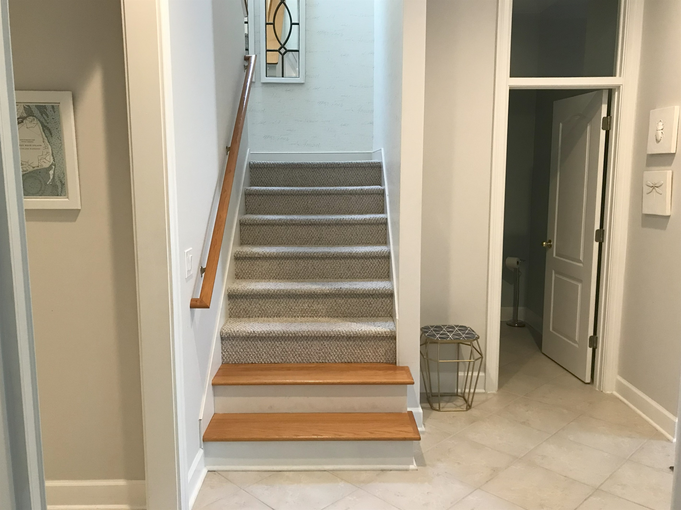 Stairs to second floor, powder room on right