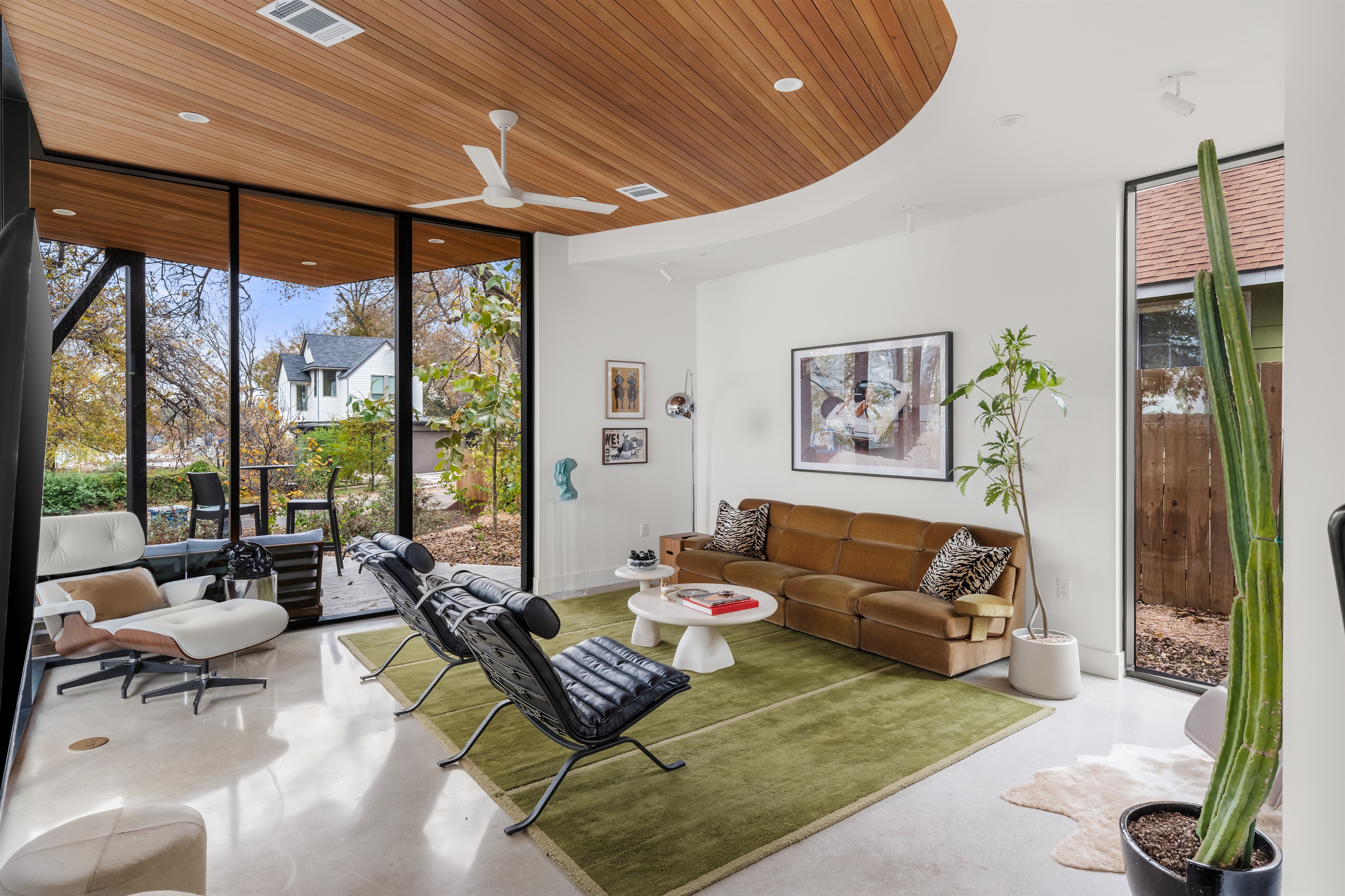 Sun-filled living room with floor-to-ceiling windows, blending indoor comfort with outdoor views.