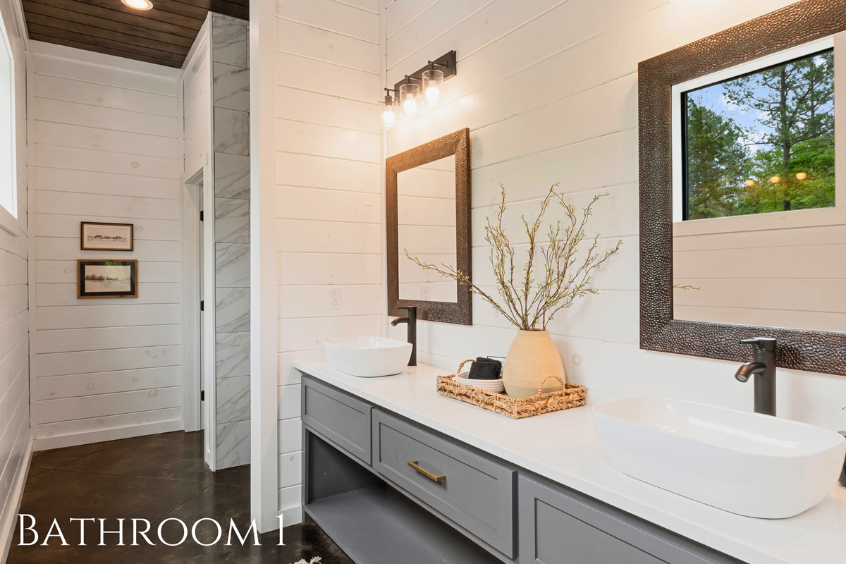 This bathroom blends modern design with rustic touches, featuring a spacious walk-in shower and a stylish vanity, for a refreshing start to your day.