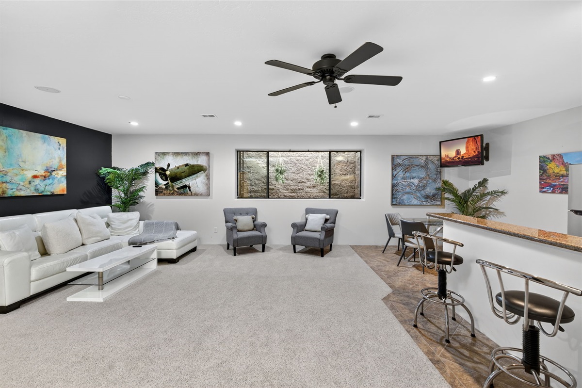 Expansive basement entertainment zone with seating and open layout designed for relaxing and socializing
