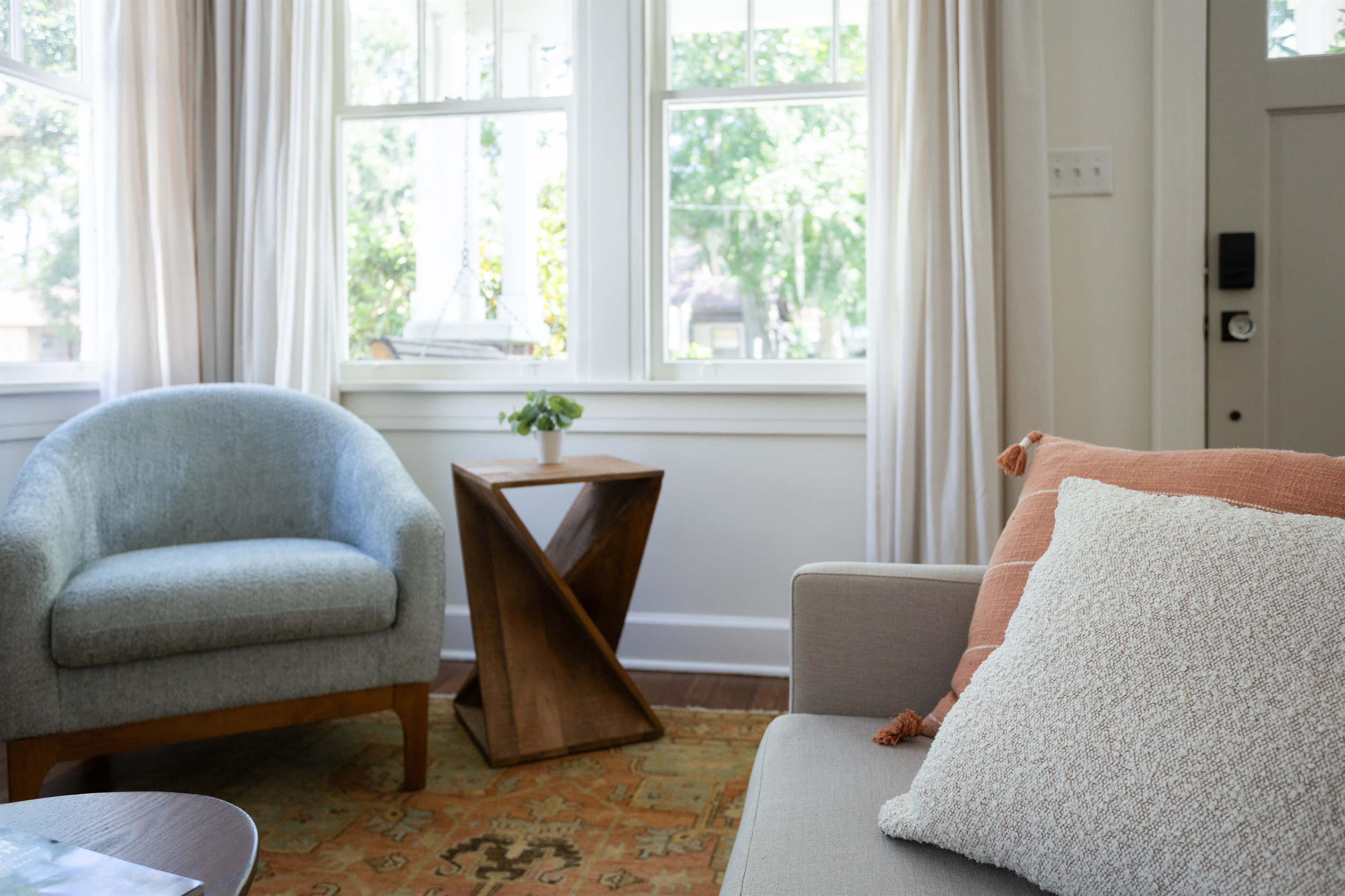 Sunlight streams through large windows, creating a warm, inviting glow throughout the living space.