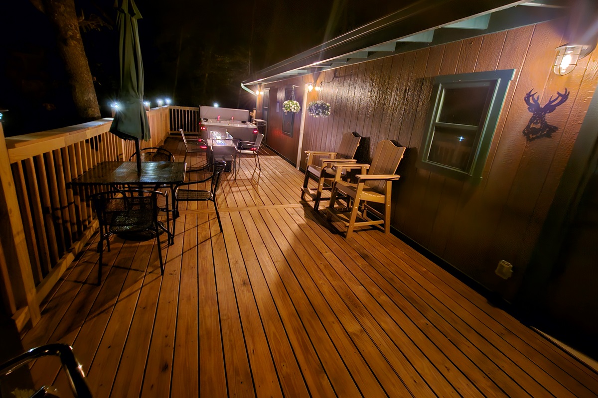 End the evening on the deck — fire glowing, lights twinkling, and the forest all around you.