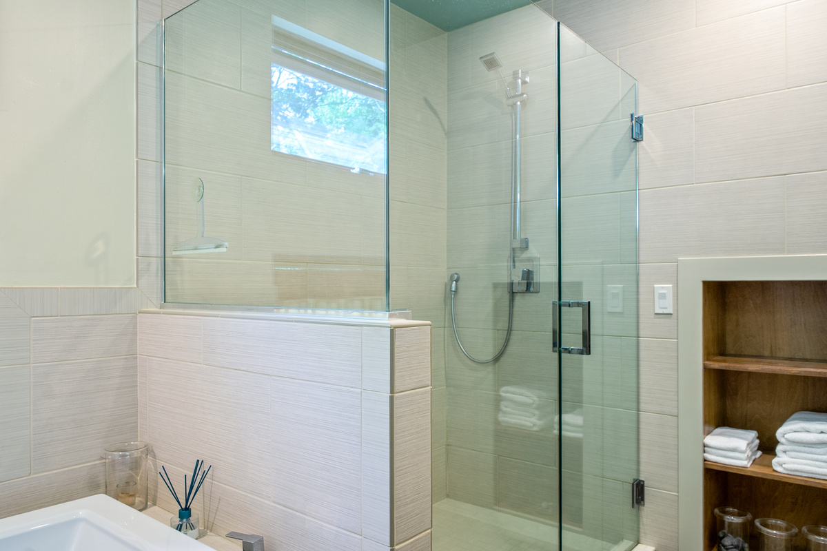 Custom floor-to-ceiling tiled shower in the primary ensuite. This modern glass enclosure features premium fixtures and built-in linen storage, providing a clean, spa-like experience at the heart of the master wing.