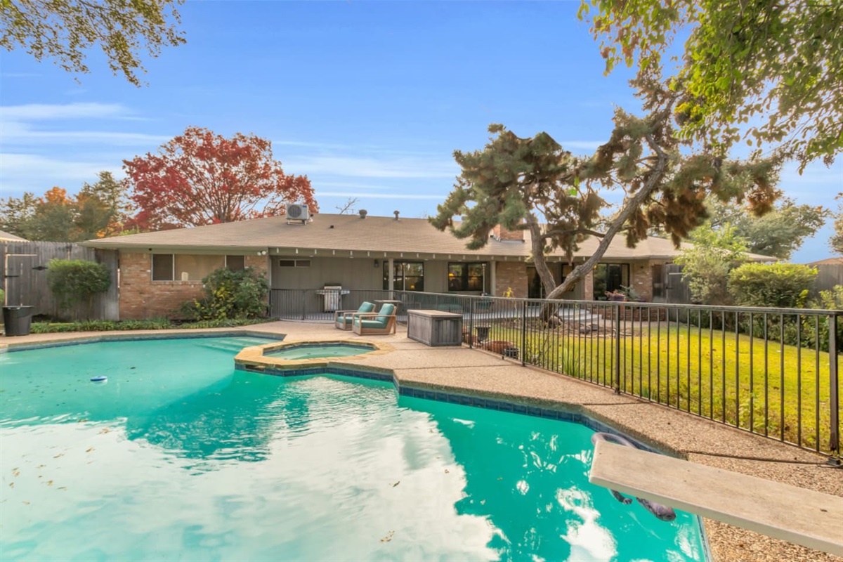 Large private pool featuring a diving board, offering a fun and refreshing space to swim, relax, and enjoy sunny Dallas days.