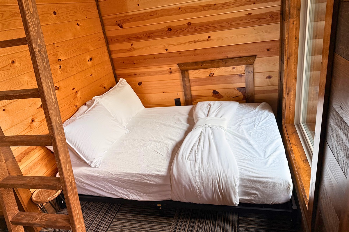 Peaceful bedroom corner featuring soft bedding and natural wood tones.