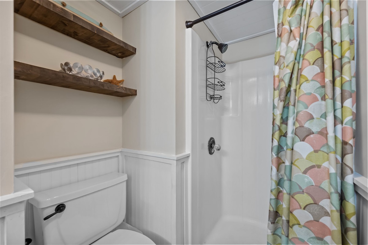 Main floor bathroom with shower and shelving