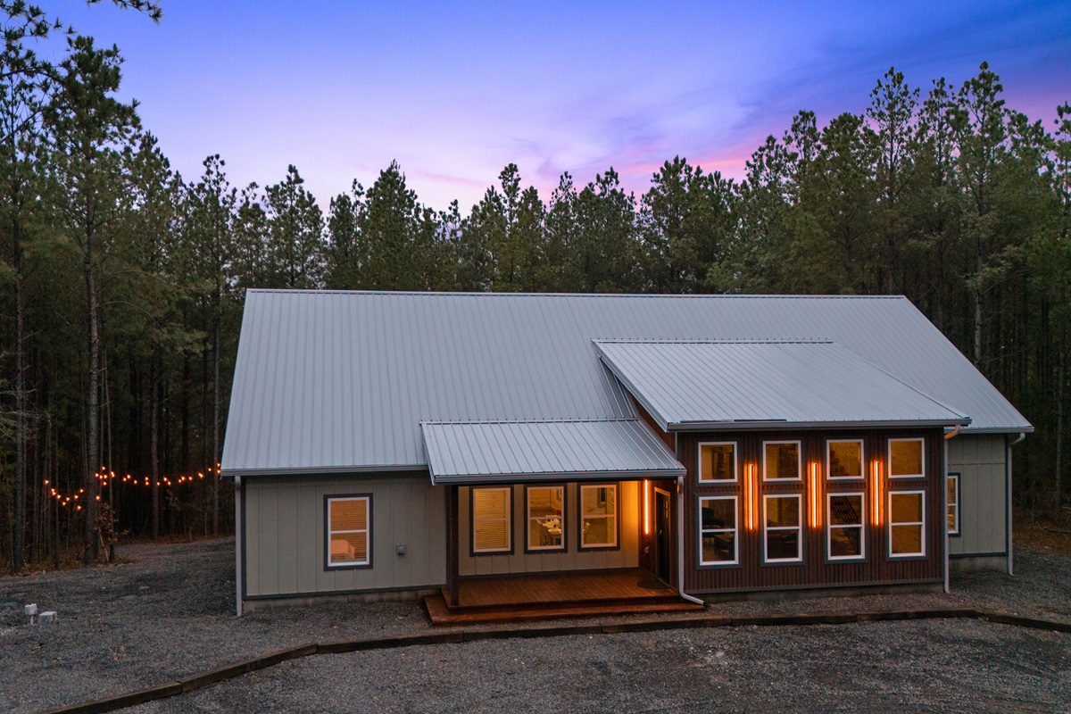 From this angle, the size and design of the cabin really stand out, showing off the inviting porch and spacious layout tucked among the trees.
