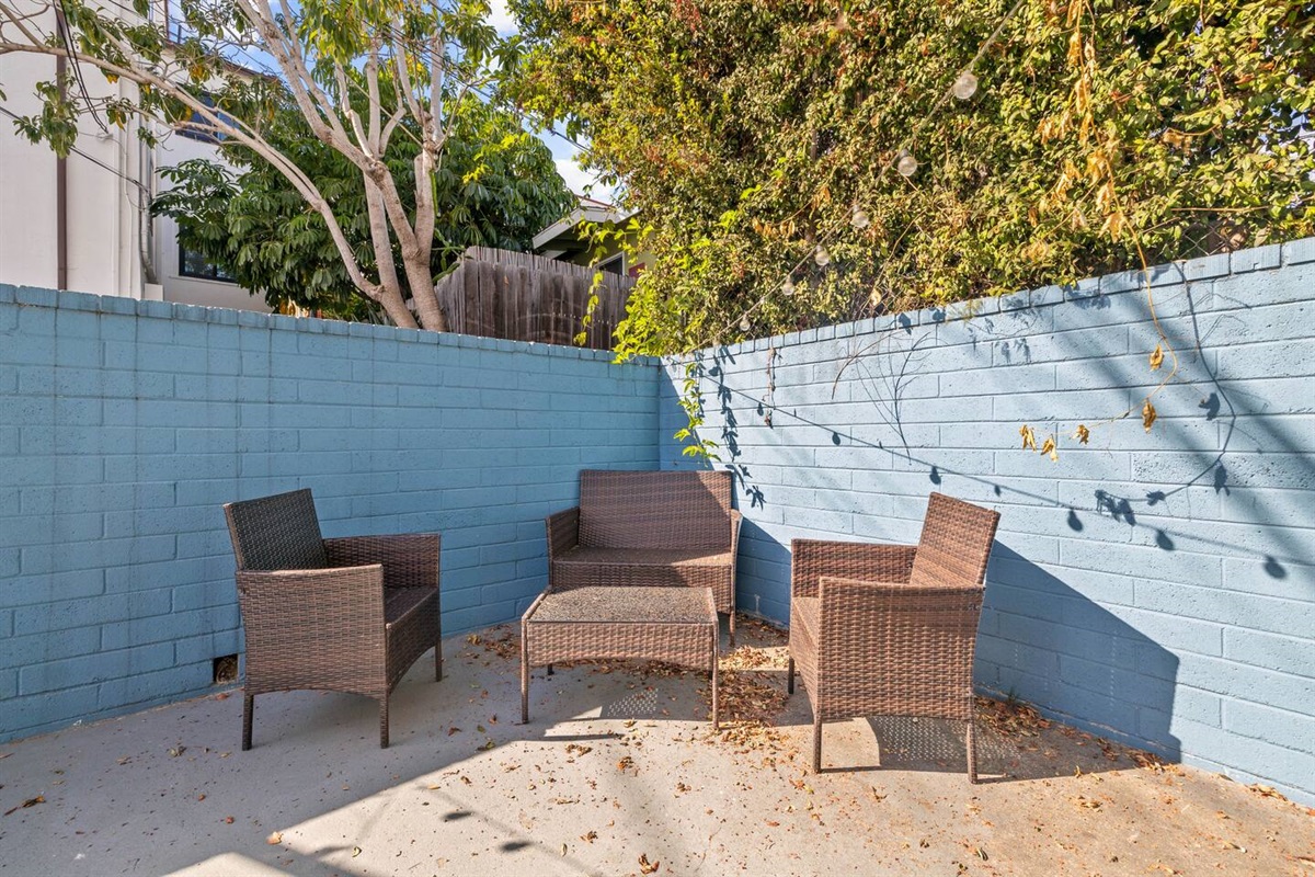 Charming exterior featuring four aesthetic chairs surrounding a stylish table, creating an inviting outdoor seating area. This lovely setup is perfect for enjoying morning coffee or relaxing in the fresh air, enhancing the home’s welcoming atmosphere