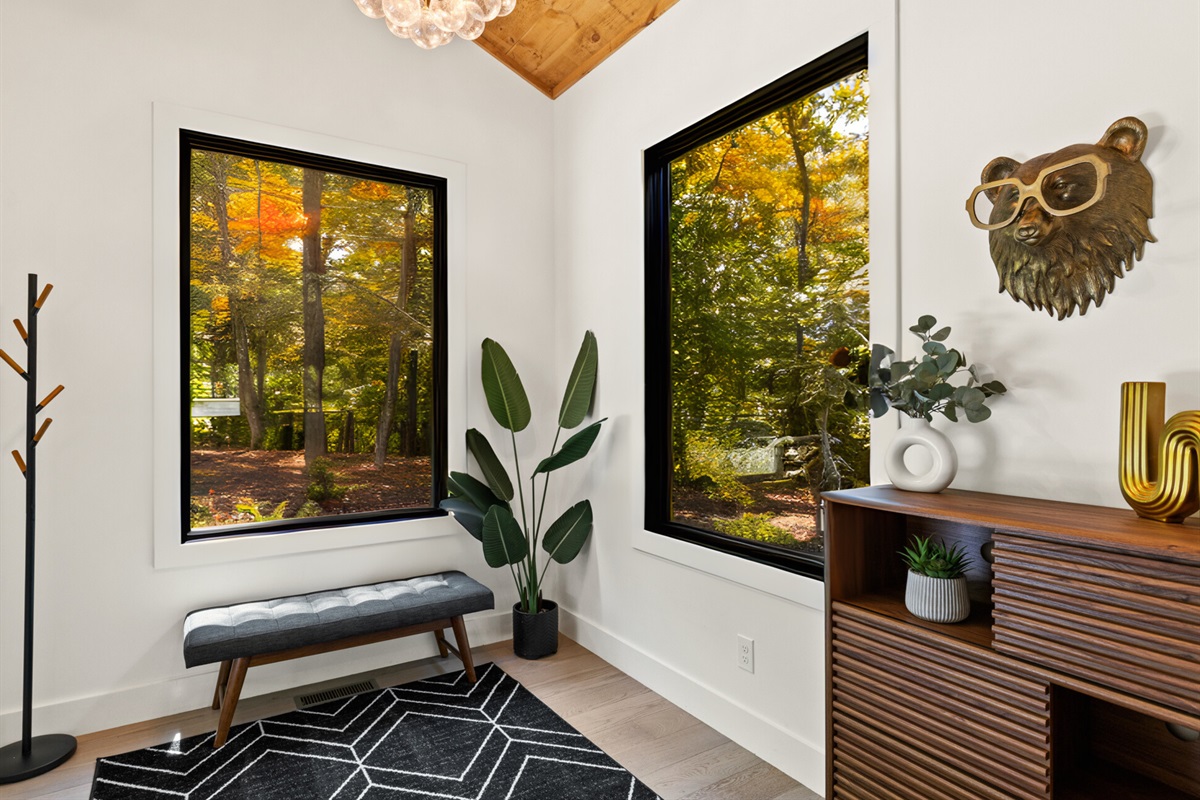 A peaceful reading nook with woodland views, earthy decor, and cozy seating for quiet moments.
