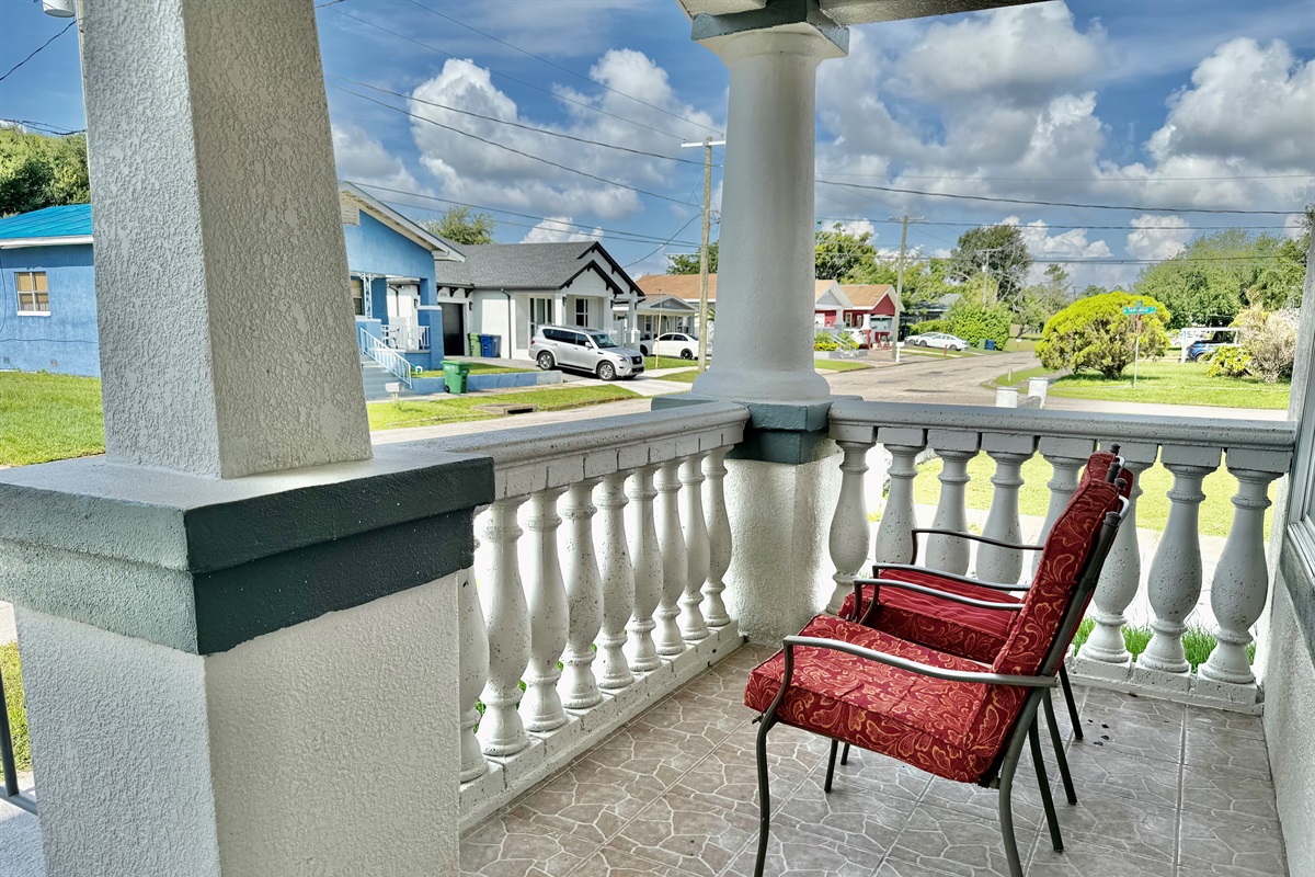 Framed by elegant columns and tropical landscaping, this tiled veranda is the perfect spot for quiet moments or casual conversation.