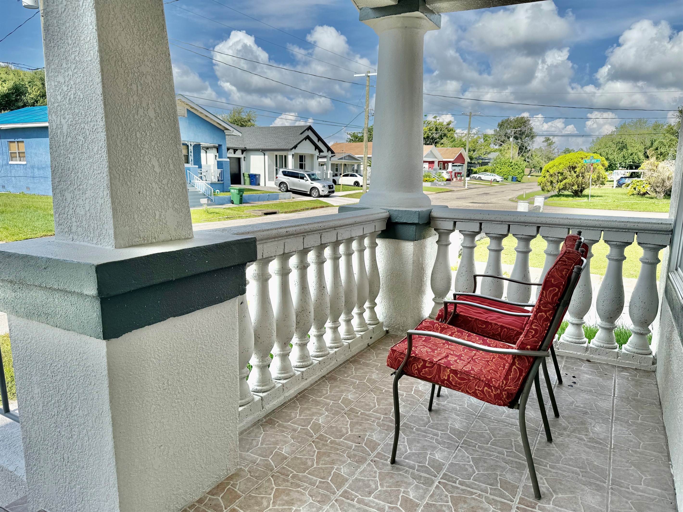 Framed by elegant columns and tropical landscaping, this tiled veranda is the perfect spot for quiet moments or casual conversation.