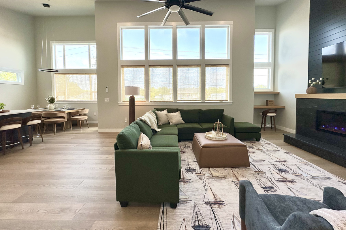 Drop your bags and claim a corner of the sectional — fire on, game up on the big screen, sunlight pouring down two stories of windows while the group trickles in.