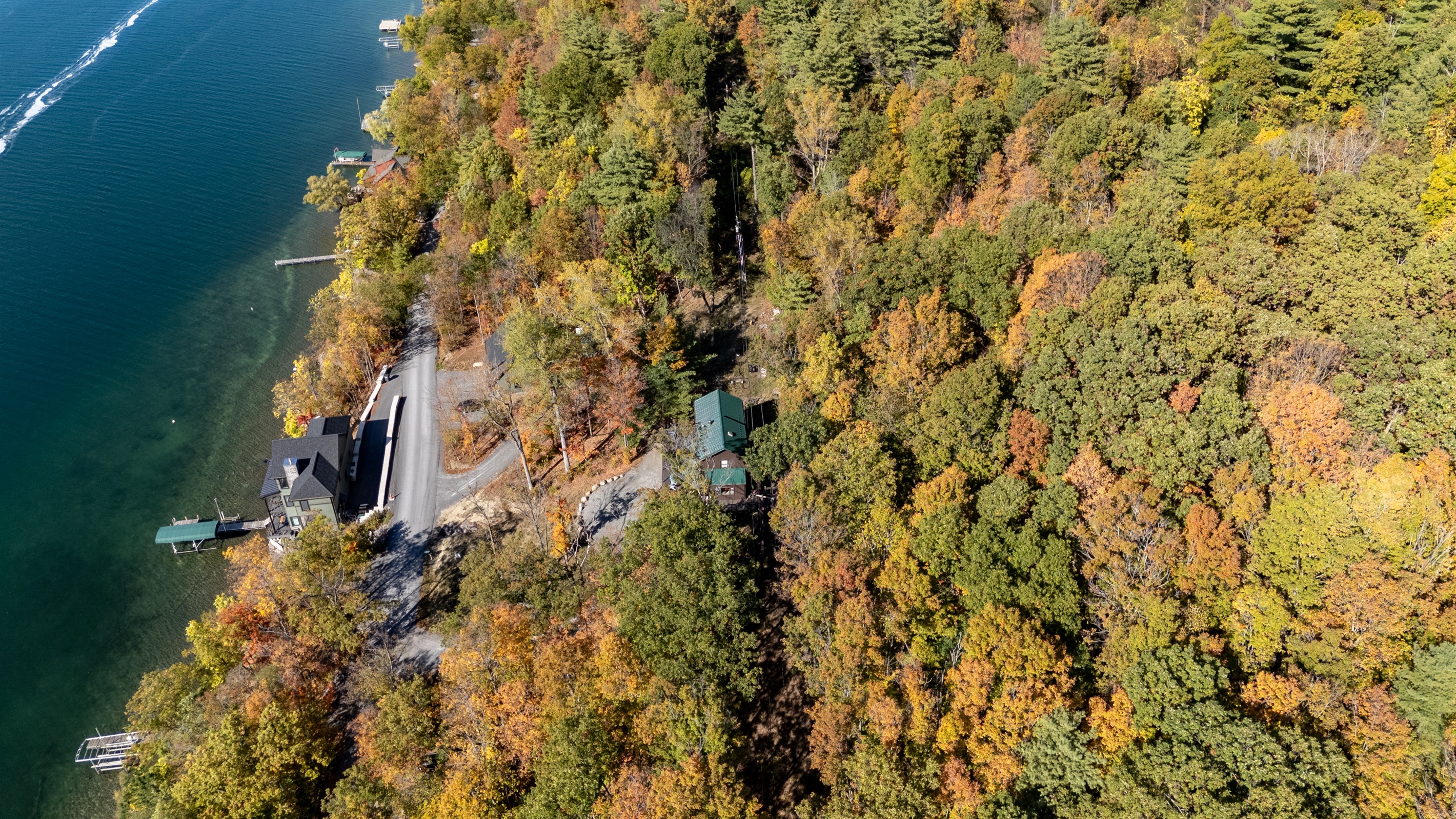 Leaf-covered treetops frame the home’s elevated position for sweeping lake views.