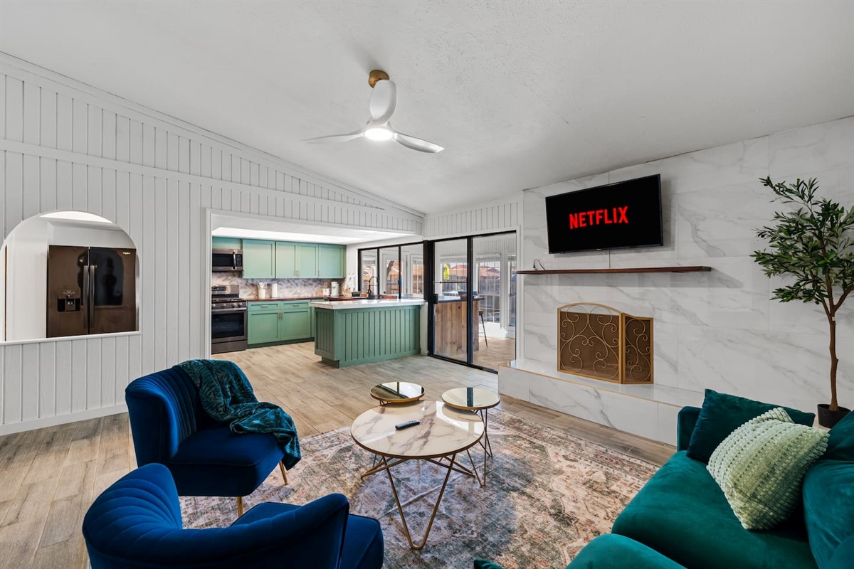Open-concept living at its best—oversized living room with mounted TV and modern furniture flowing into the kitchen.