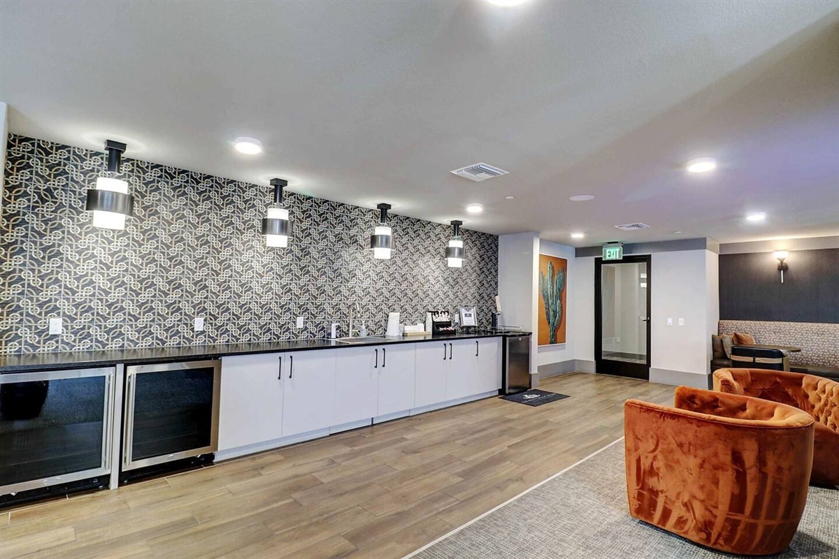 - Relax in the stylish clubroom with a long bar counter and cozy lounge chairs   - Enjoy complimentary coffee, modern lighting, and a chic patterned backdrop   - Great for casual chats, social meetups, or productive workspace sessions