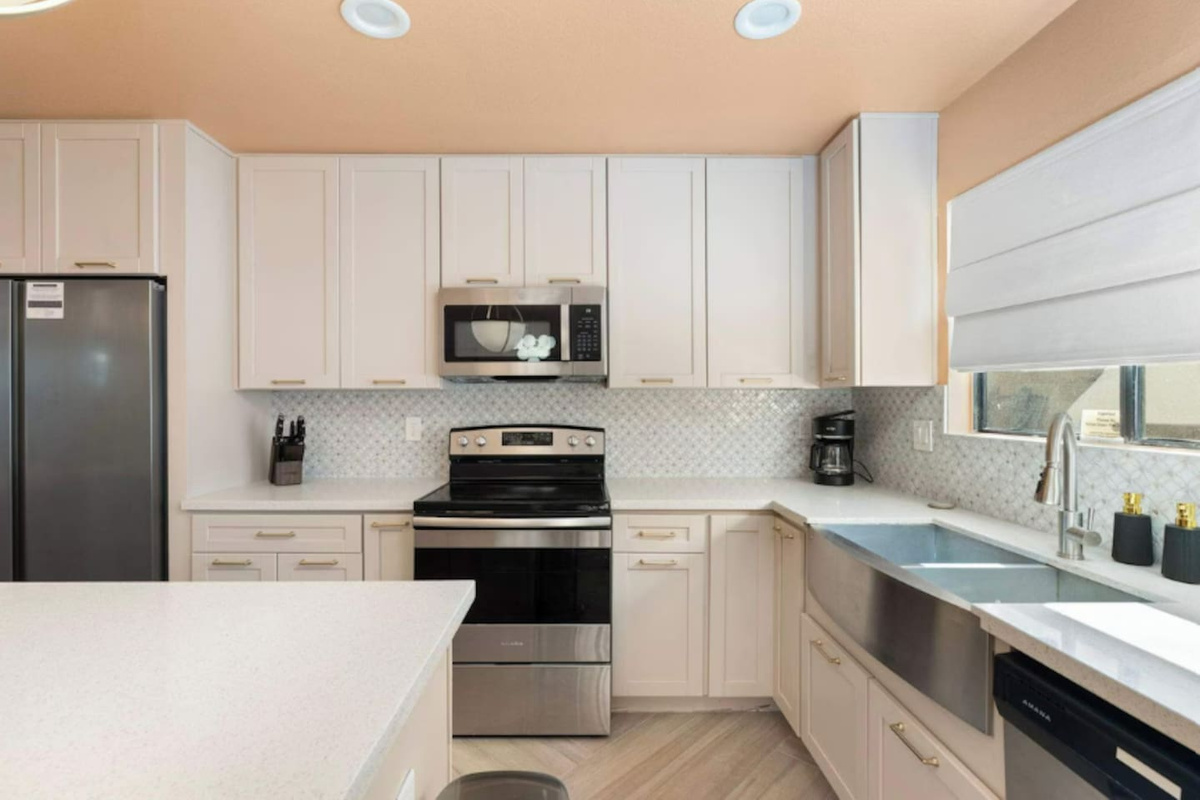 Modern kitchen with white cabinetry, stainless steel appliances, and quartz counters—fully equipped for cooking and entertaining.