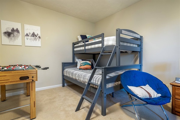 Twin-over-full bunk room, also featuring a foosball table and sitting area around big-screen TV.   