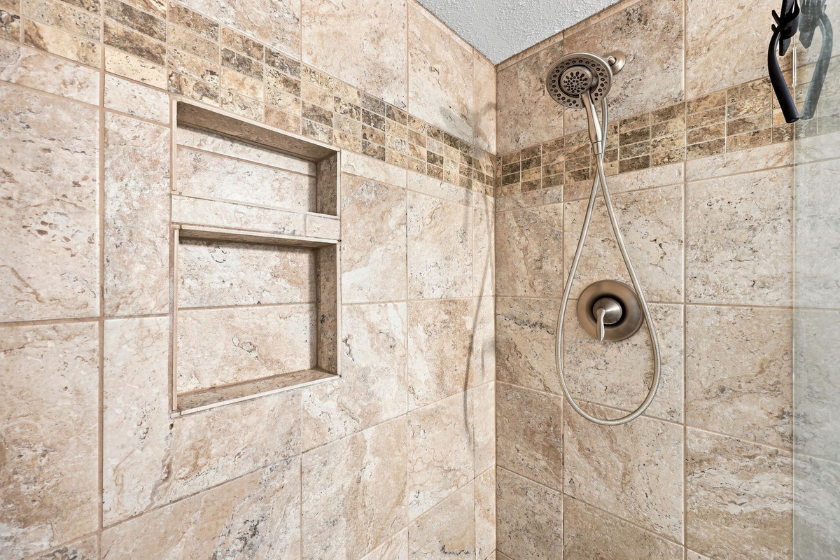 Clean and modern shower setup featuring premium fixtures and a soothing neutral tile design.