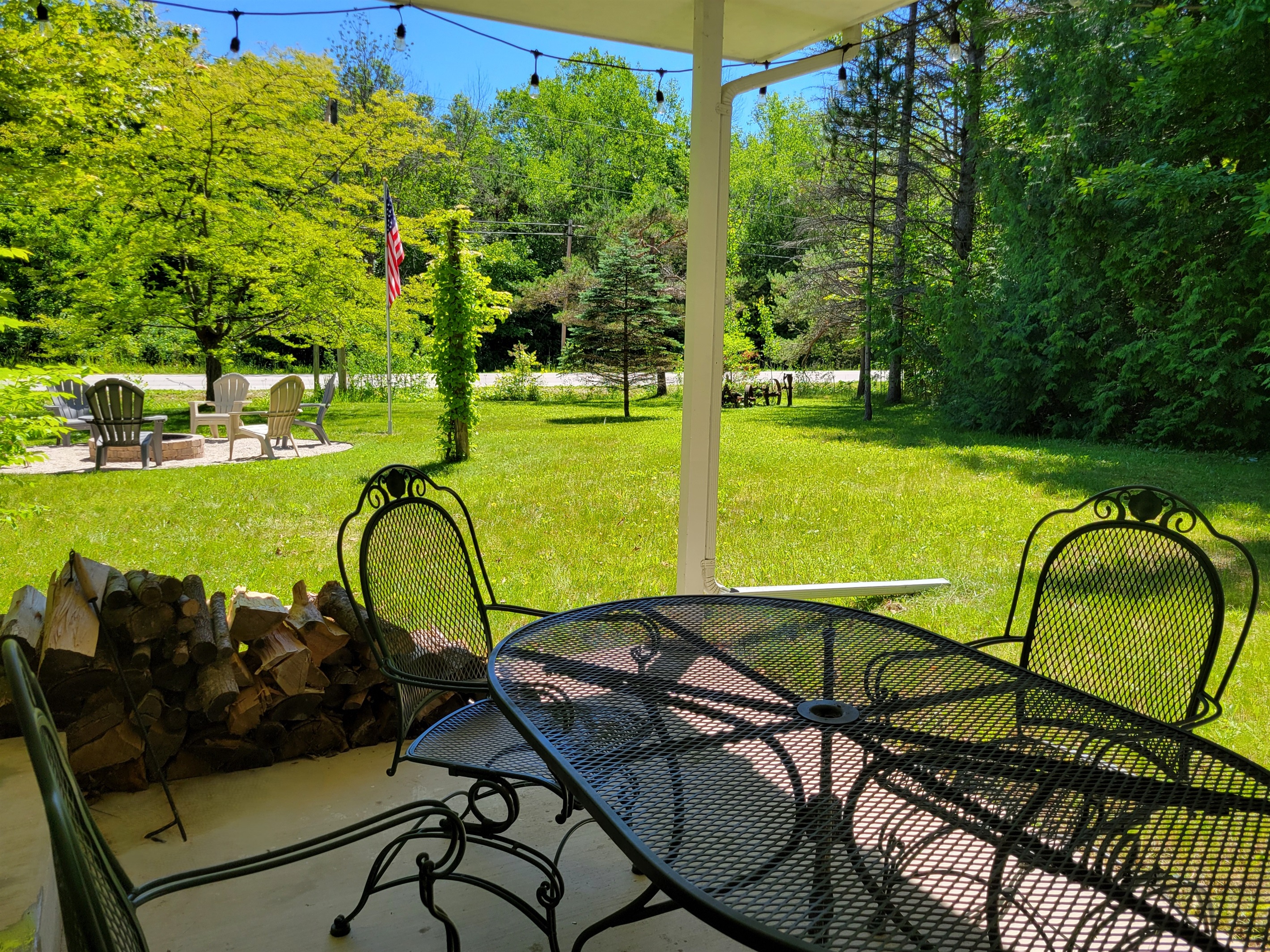 Main Porch: covered, seating for 6+, charcoal grill, string lights, close to the fire pit