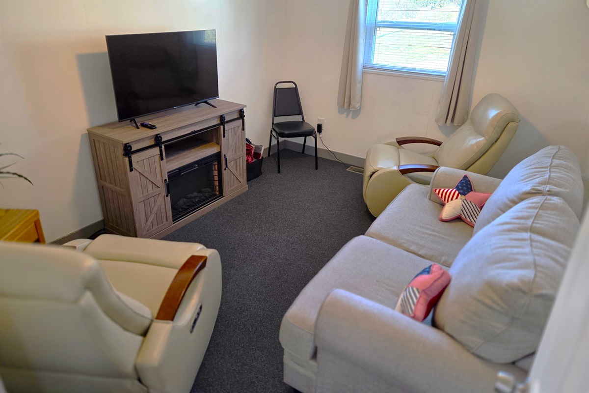 The living room features a smart TV, 2 recliners, sofa, and fireplace for ambiance.
